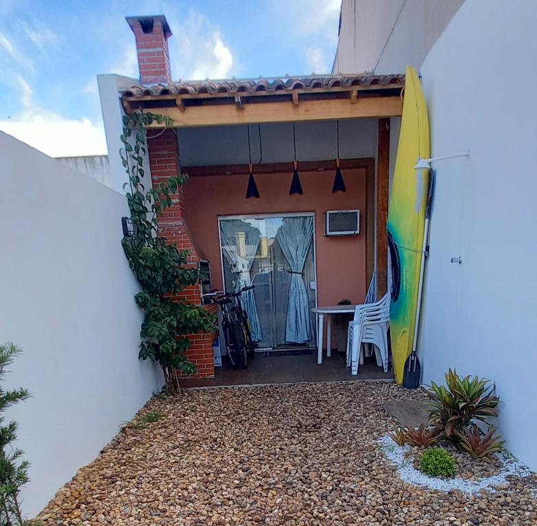 une terrasse avec une table et une planche de surf sur une maison dans l'établissement Casa totalmente climatizada, à São Lourenço do Sul