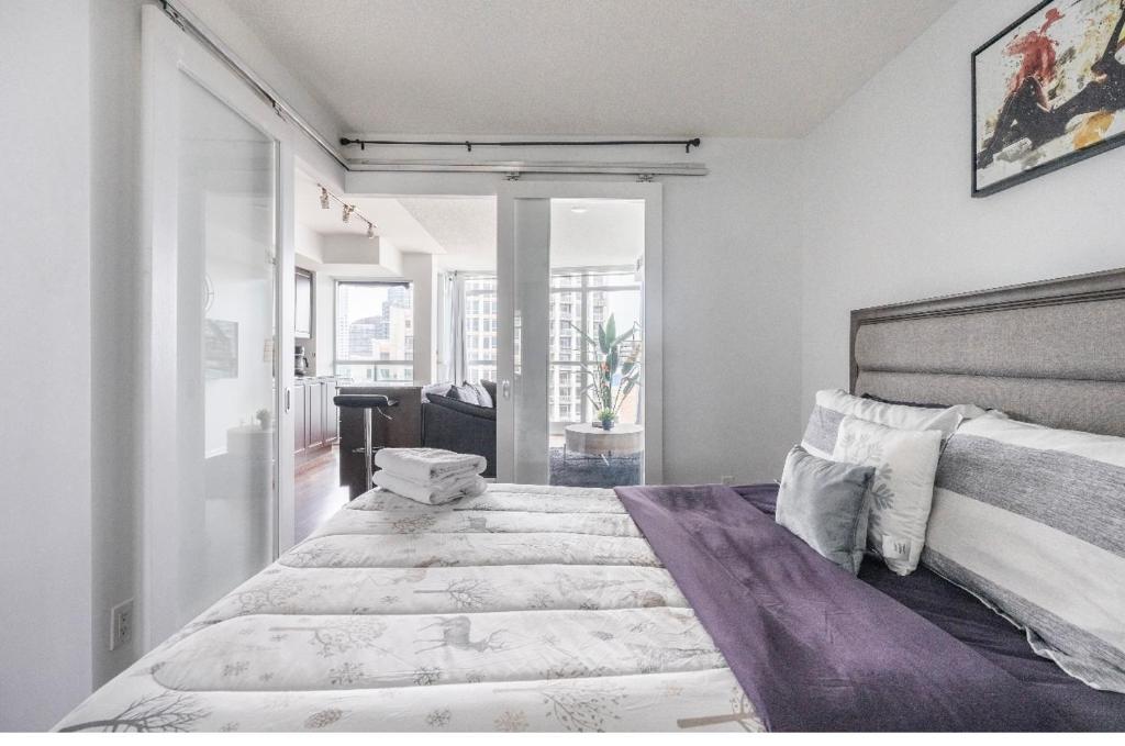 een witte slaapkamer met een groot bed. bij Toronto downtown Fort York suites 1BDRM with parking in Toronto