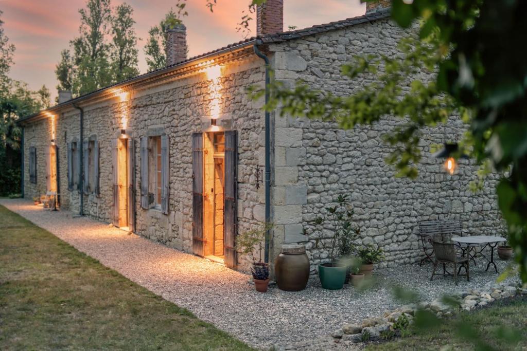 una casa de piedra con luces en el lateral. en La Nuit & Le Jour, en Vertheuil-en-Médoc