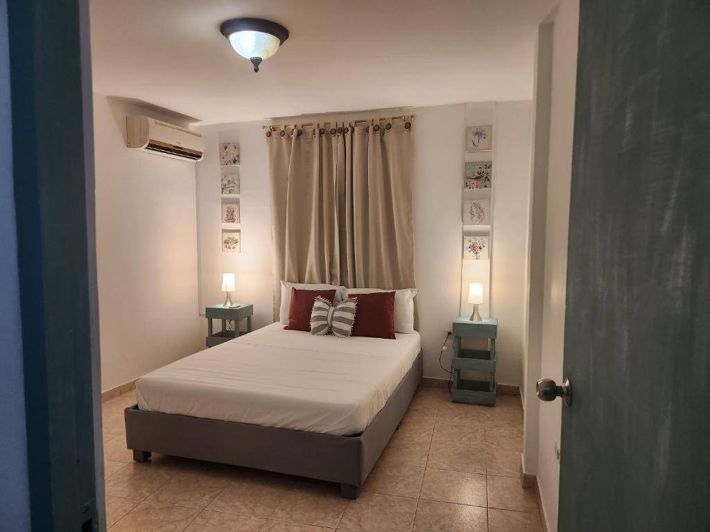 una camera con un letto con due comodini e due lampade di Apartahotel Santori Cartagena a Cartagena de Indias