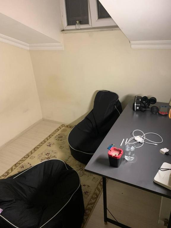 um quarto com duas cadeiras pretas e uma mesa em Halkalı merkez küçük lüks oda em Istambul