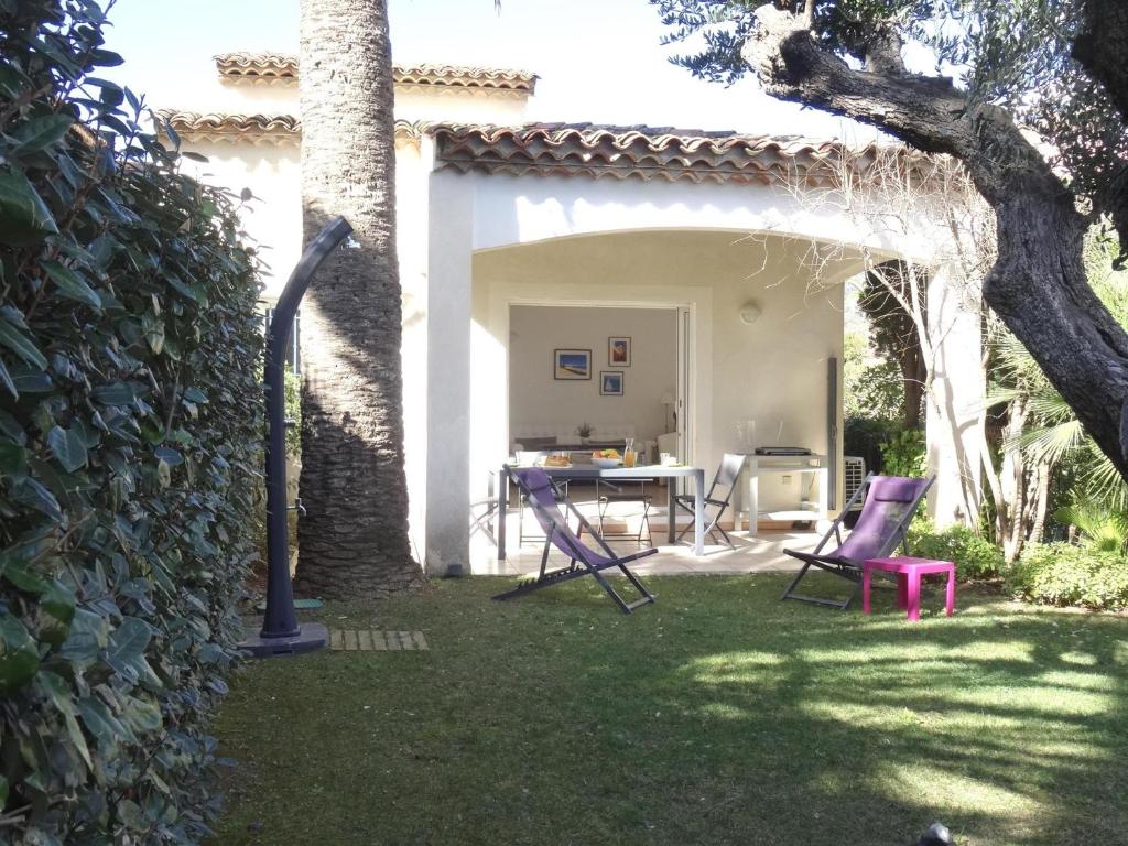d'une terrasse avec des chaises et une table dans la cour. dans l'établissement Villa 4*** à 20m de la plage, jardin, parking, clim, WIFI - FR-1-728-15, à Cavalaire-sur-Mer