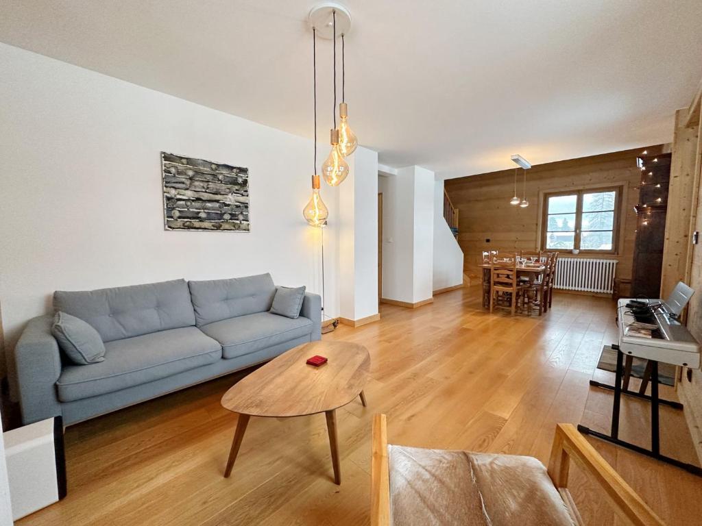 un salon avec un canapé et une table dans l'établissement Appartement calme près du lac avec jardin, balcon, parking et wifi - FR-1-624-150, à Samoëns