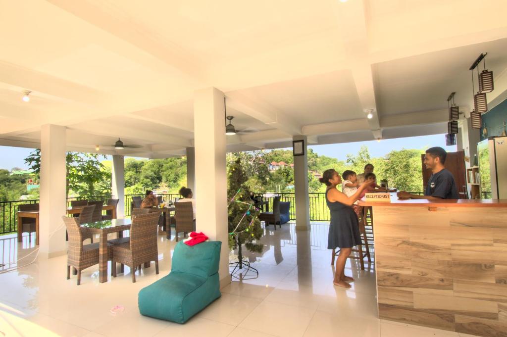 a group of people standing at a bar in a restaurant at Hotel Bonne Nuit in Labuan Bajo