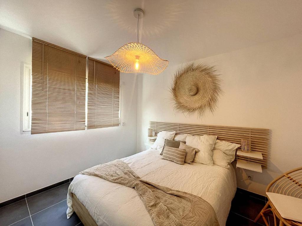 a bedroom with a large bed and a chandelier at Appartement Calvi, 2 pièces, 4 personnes - FR-1-719-13 in Calvi