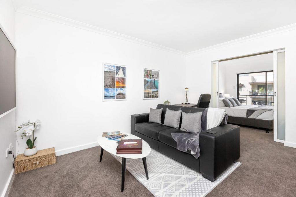 a living room with a couch and a bed at City View 1br Gem On Mounts Bay Road in Perth