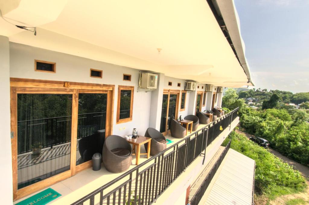 a balcony of a house with chairs and a view at Hotel Bonne Nuit in Labuan Bajo