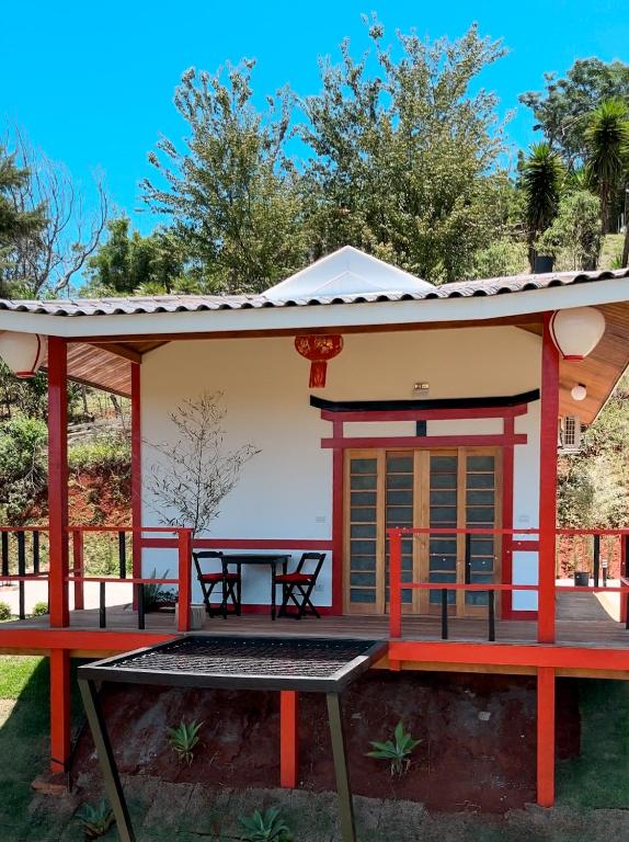 a small house with a patio and a table at Mundarium - Chalés Temáticos com Hidromassagem e Cromoterapia in Santo Antônio do Pinhal