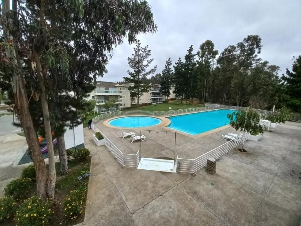 einen Blick über einen Pool mit Stühlen um ihn herum in der Unterkunft Quebrada de la Candelaria III in Algarrobo