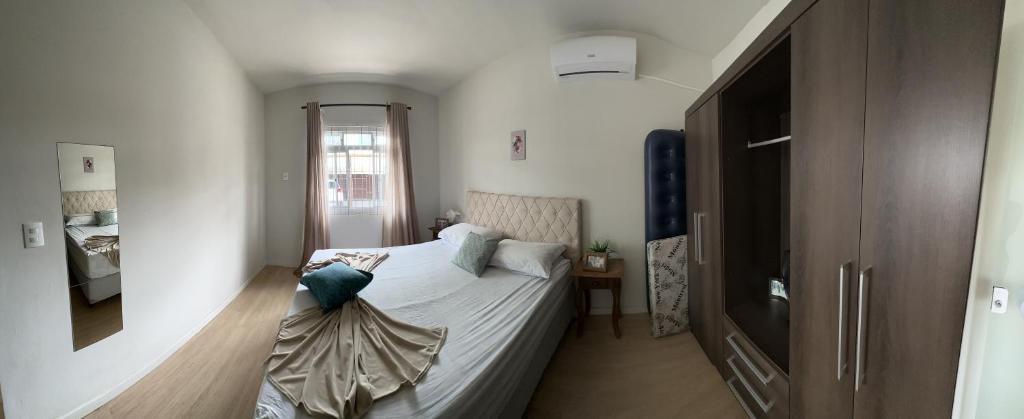 um pequeno quarto com uma cama e uma televisão em Residencial Marina em Florianópolis