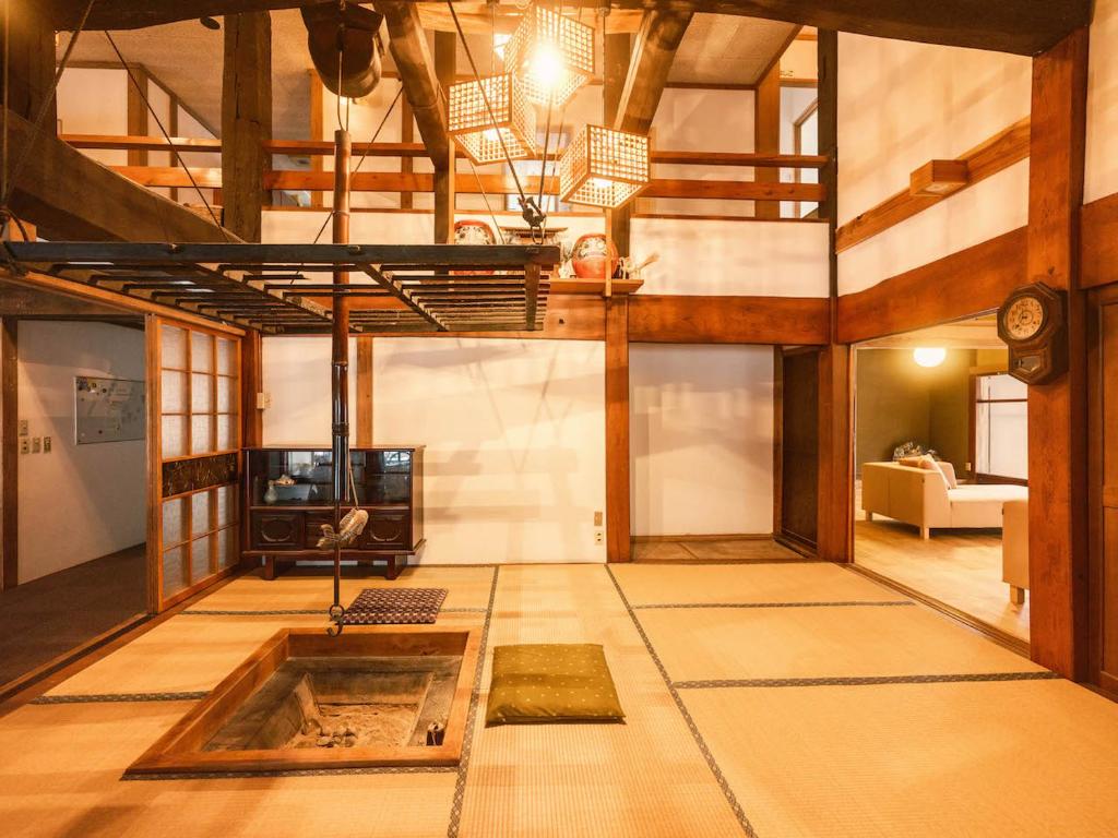 a large living room with a couch and a tv at 古民家ホテル 結 YUWAI in Hakuba
