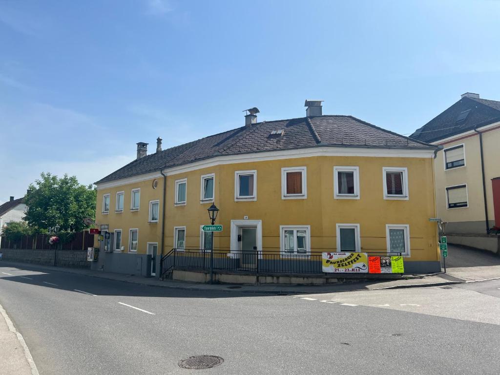 a yellow house on the side of a street at Gästezimmer Euratsfeld in Euratsfeld