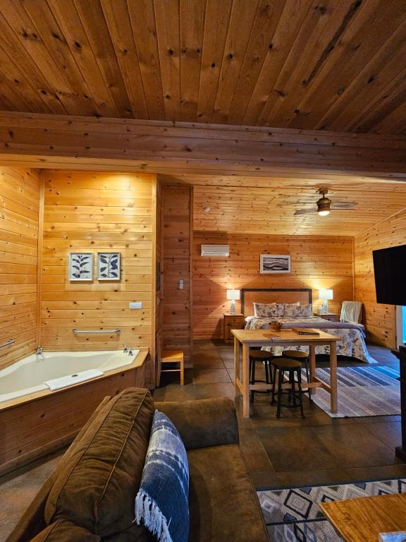 a living room with a tub and a table and a bed at 5 Min To Beaver Lake, King Bed, Fire Pit, Jetted Tub #3 in Eureka Springs