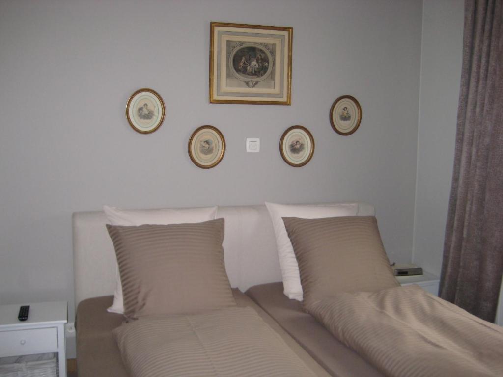 ein Schlafzimmer mit einem Bett mit zwei Kissen und Platten an der Wand in der Unterkunft Nobel in Westende