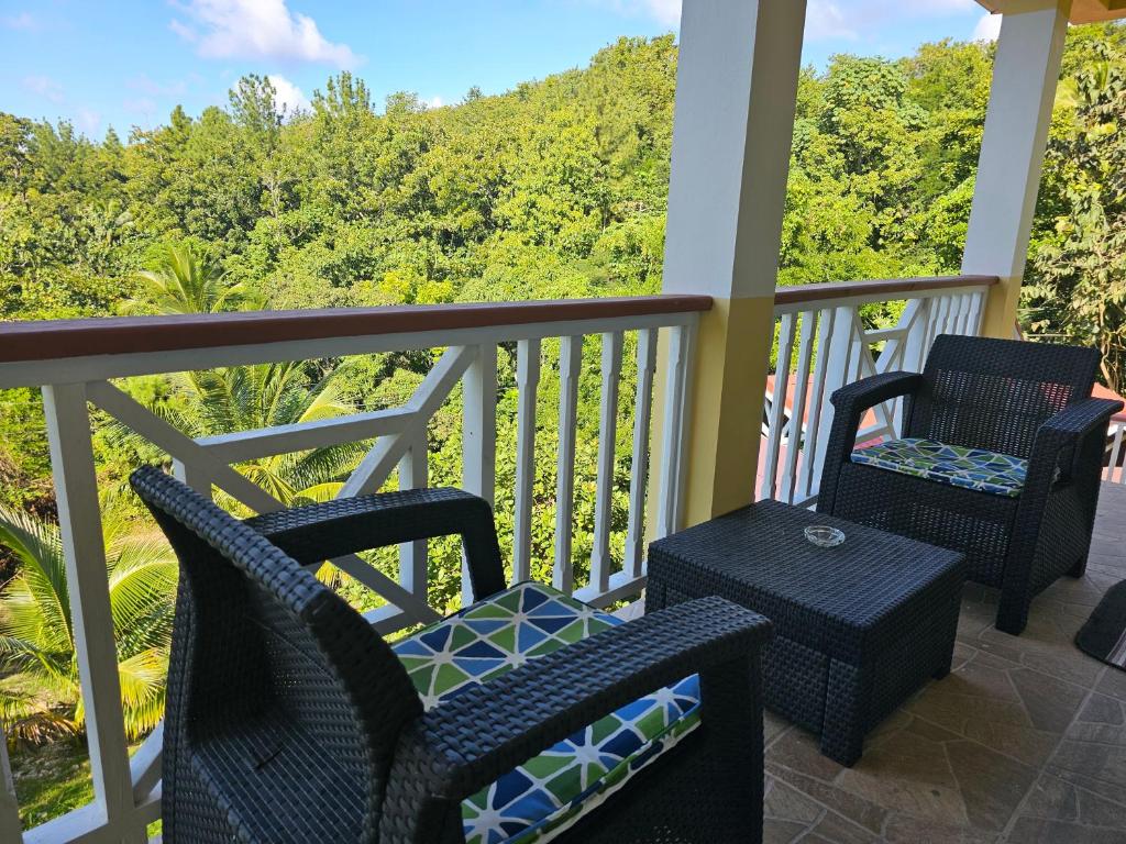 2 sillas y una mesa en un porche con vistas en Royal Escape - 2 en Anse La Raye