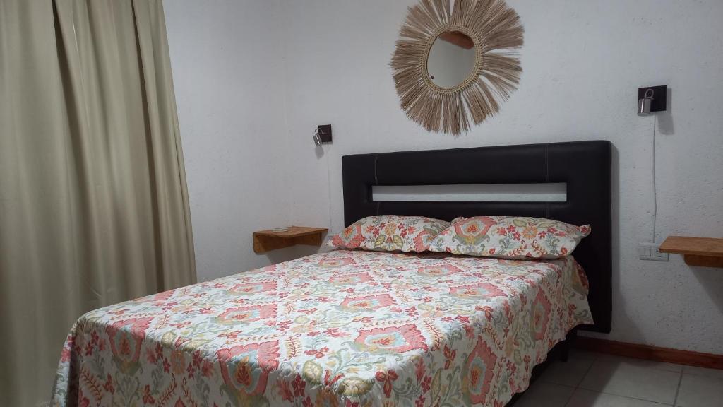 1 dormitorio con cama con edredón y espejo en DON BAUTISTA en Santa Rosa de Calamuchita