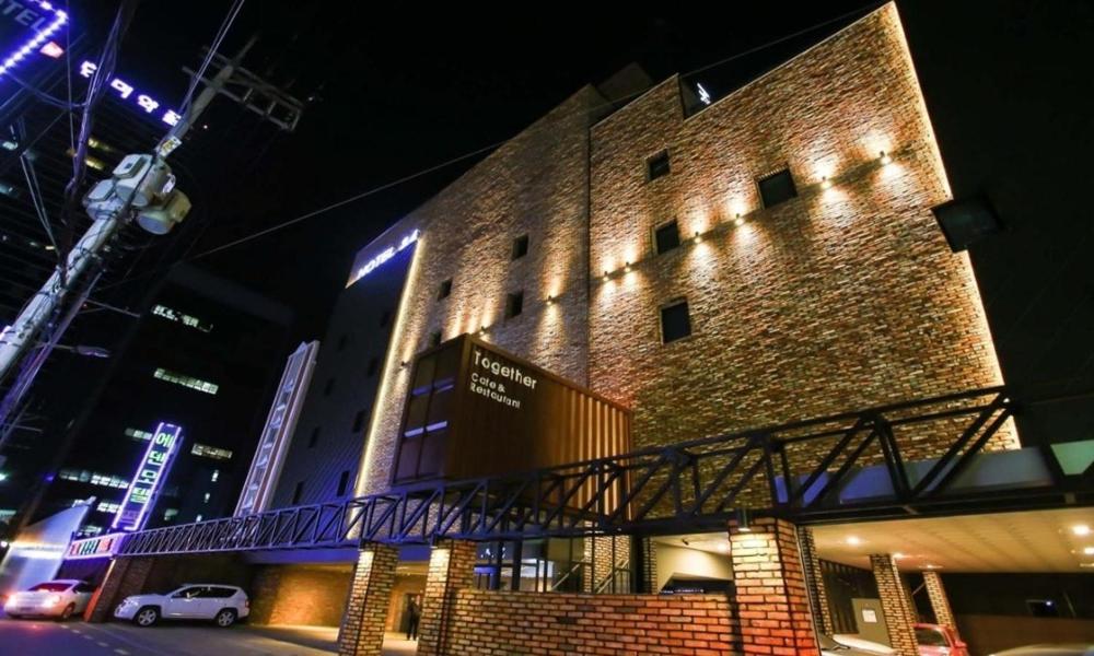 a large brick building with a walkway in front of it at Jamsil 2.4 Hotel in Seoul