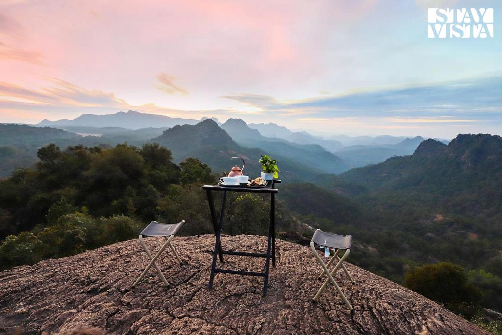 una persona seduta a un tavolo in cima a una montagna di StayVista's Pandav Greens - Eco-Stay with Lawn & Bonfire a Pachmarhī