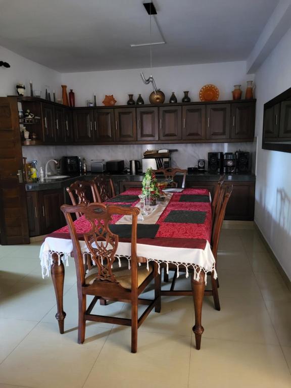 uma mesa de jantar com uma toalha de mesa vermelha e branca em ShaNicky Villa em Kandana
