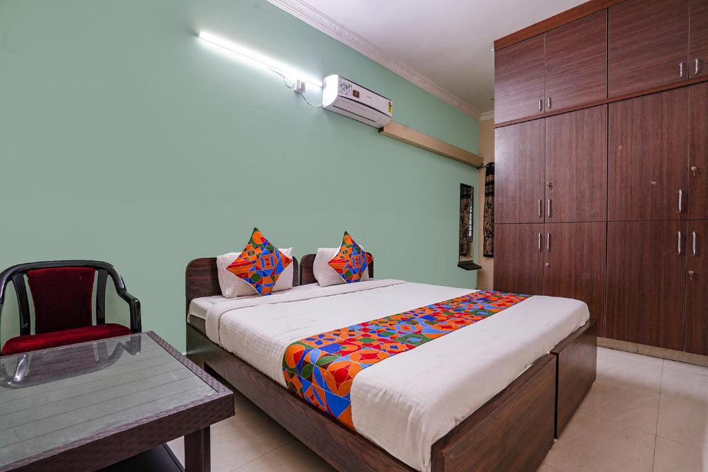 a bedroom with a bed and a chair in it at FabExpress D Grand in Hyderabad