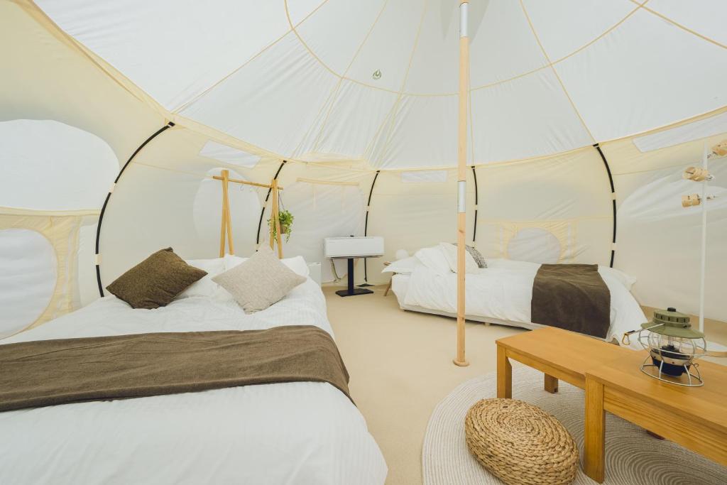 a bedroom with two beds in a tent at Yagaji Beach(屋我地ビーチ) in Nago