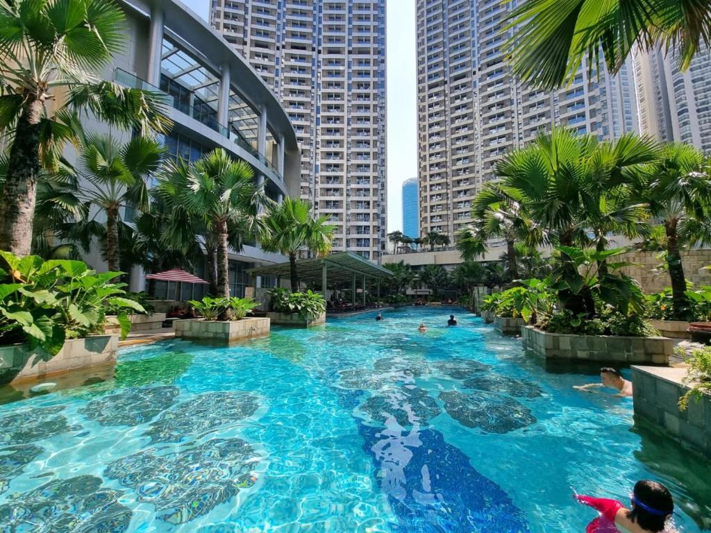 a swimming pool in a city with tall buildings at Gin Residence in Jakarta