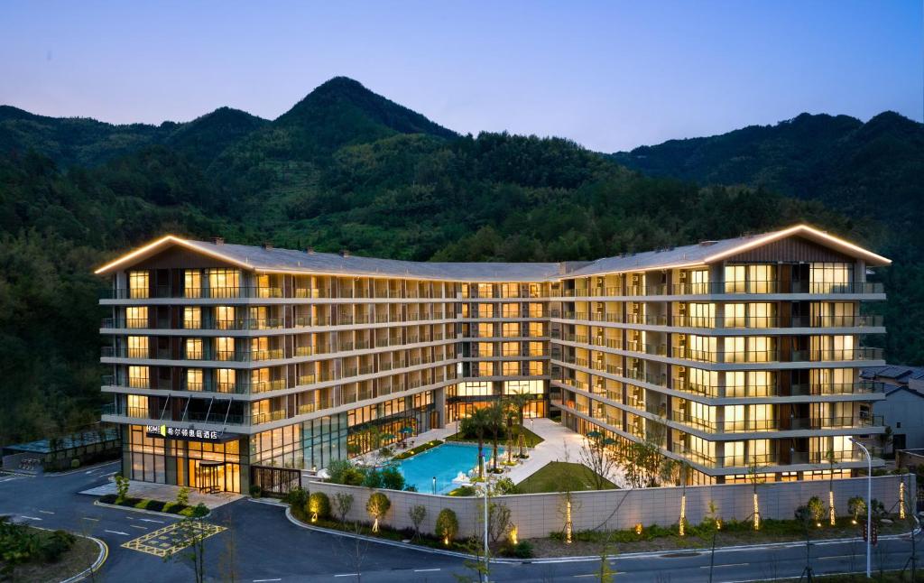 a rendering of a hotel with mountains in the background at Home2 Suite by Hilton Wenzhou Wencheng in Wenzhou