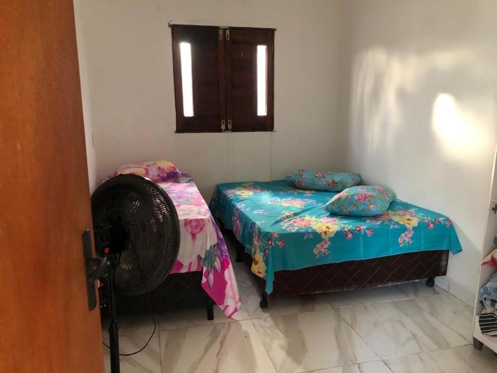 a room with two beds and a fan at Casa de ponta de pedras in Goiana