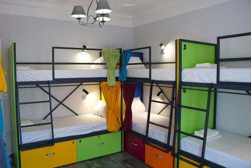 a room with four bunk beds with colorful cabinets at Up Hostel in Belgrade