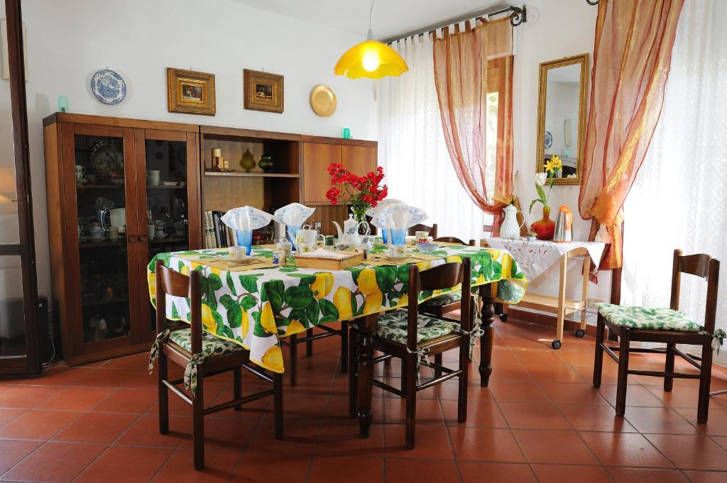 une table à manger avec un tissu de table vert et jaune dans l'établissement Villa La Certosa, à Pise