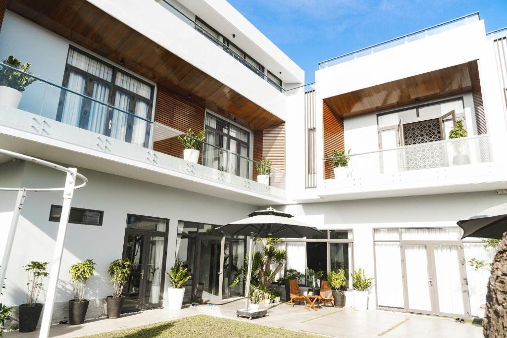 a white house with plants on the balcony at SHALOM HOUSE _ BẢO LỘC in Bao Loc