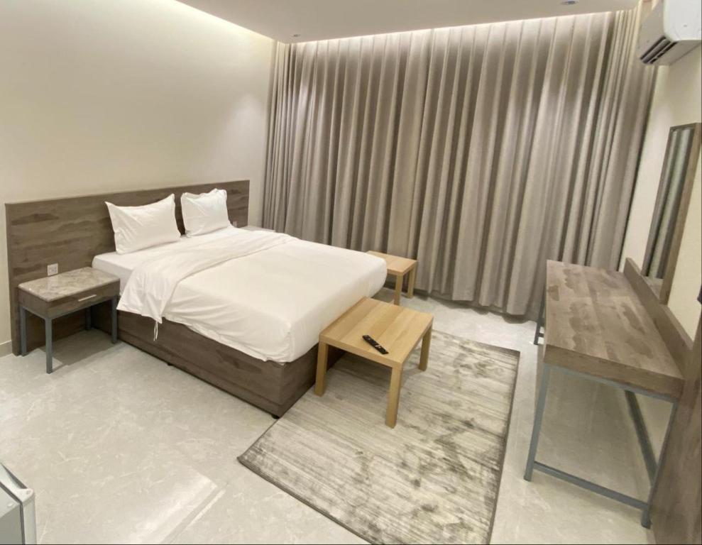 a bedroom with a large bed and a table at جده هاوس Jeddah house in Jeddah