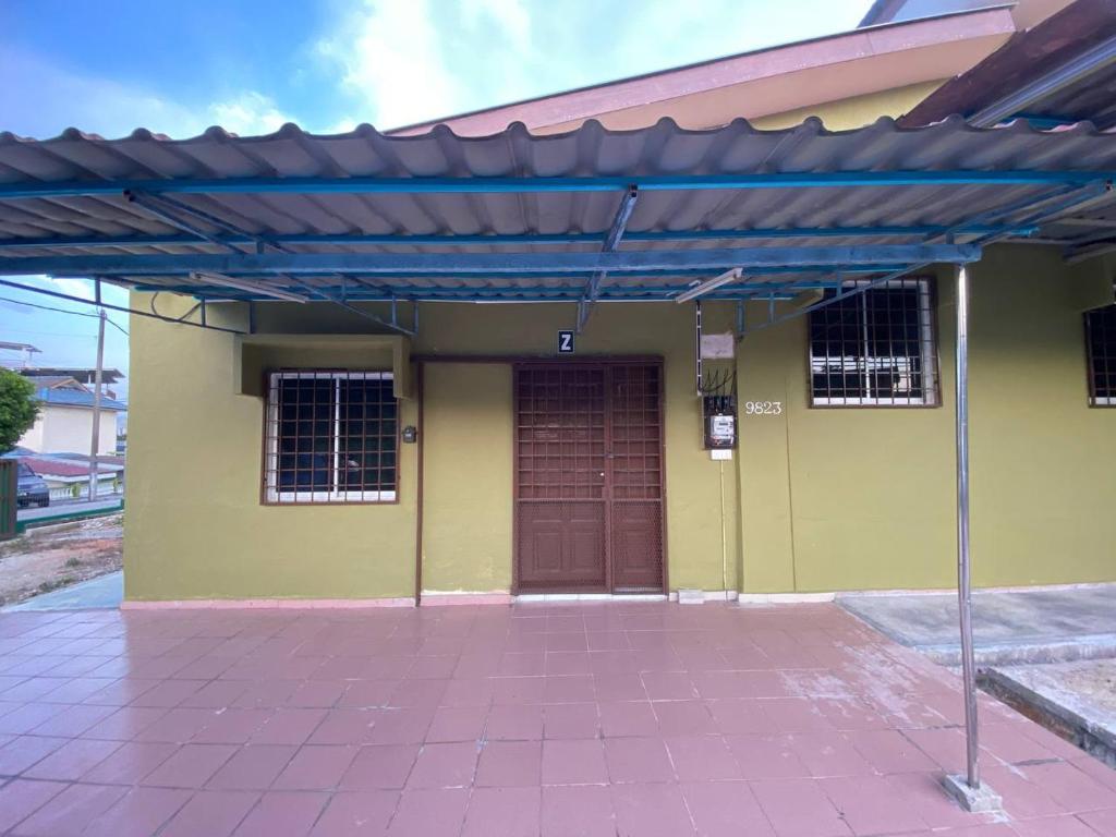 ein Haus mit einem blauen Dach und einer Garage in der Unterkunft Homestay Selayang D Kepong in Kuala Lumpur