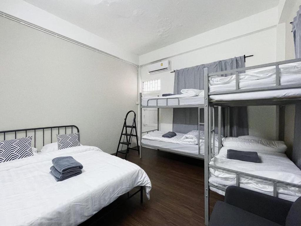 a room with two bunk beds and a ladder at Tolomhouse in Hat Yai