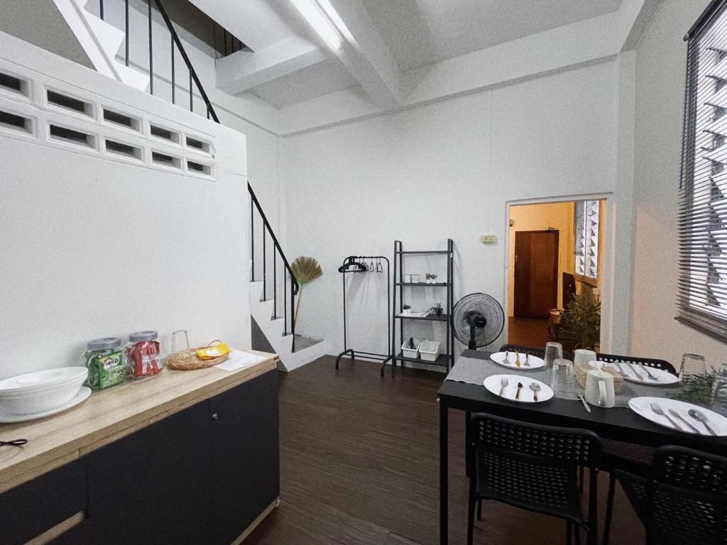 a kitchen with a table and chairs in a room at Tolomhouse in Hat Yai