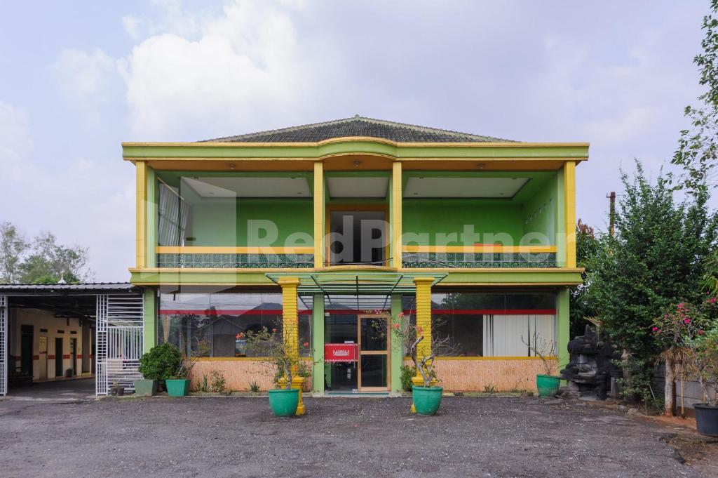 a building with yellow columns in front of it at Homestay Hj Suharti Natar Lampung RedPartner in Negarasaka