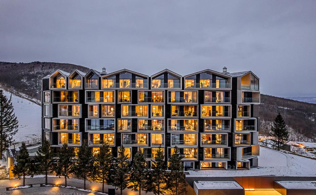 a rendering of a hotel with its lights on at MUWA NISEKO in Niseko