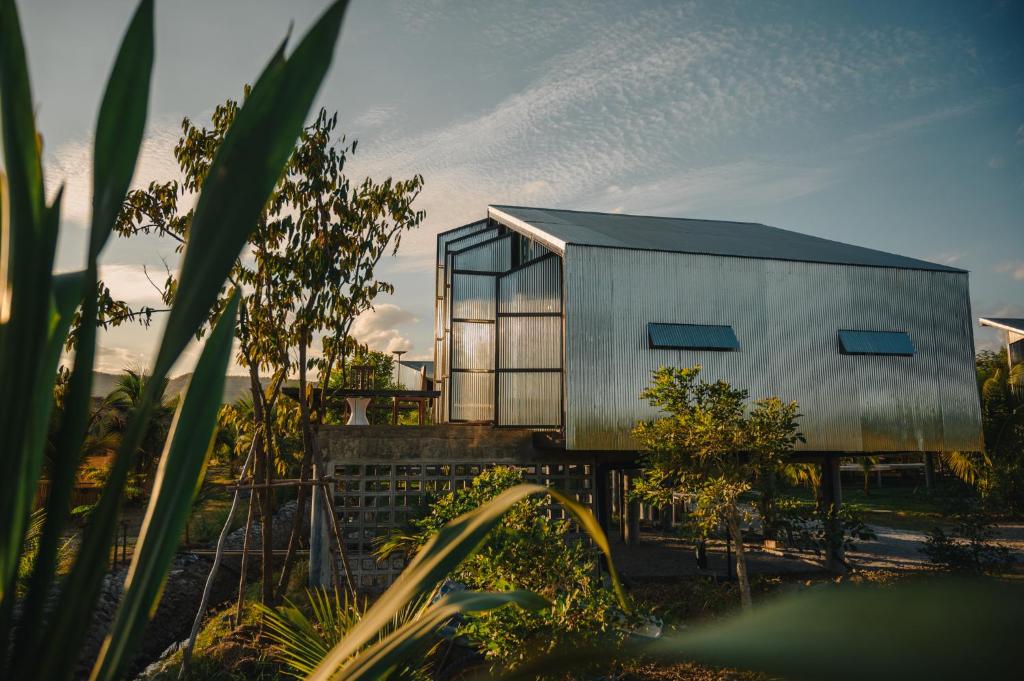 een huis met glazen ramen erop bij STAY PILAFarm in Ban Nam Chun Yai