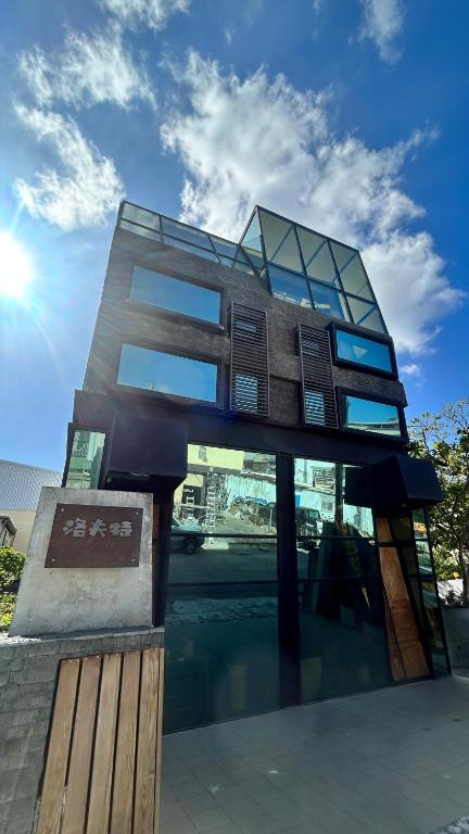 un edificio con finestre in vetro sul lato di 墾丁恆春包棟 l 洛夫特Looft民宿 a Città Vecchia di Hengchun