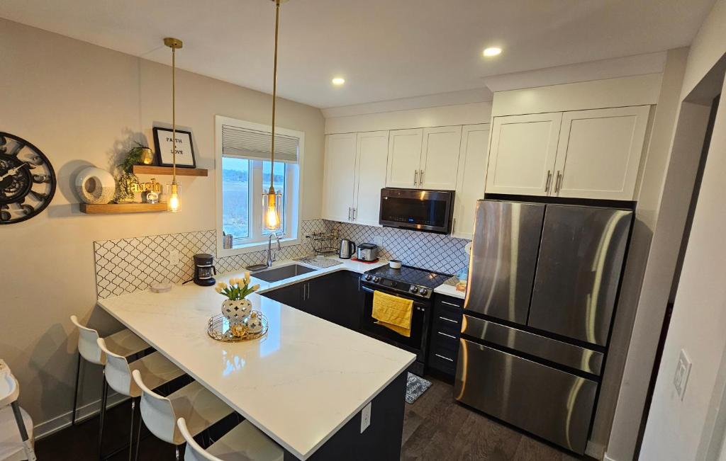 a kitchen with a refrigerator and a table with chairs at RB Homes in Ottawa