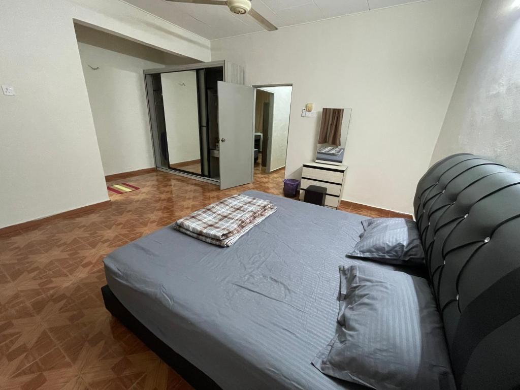 Un dormitorio con una cama con una manta. en RUFFI Homestay Taiping, en Simpang