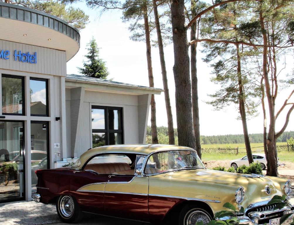 un coche viejo estacionado frente a un edificio en Privat & Boutique Hotel Plauer See, en Funfseen