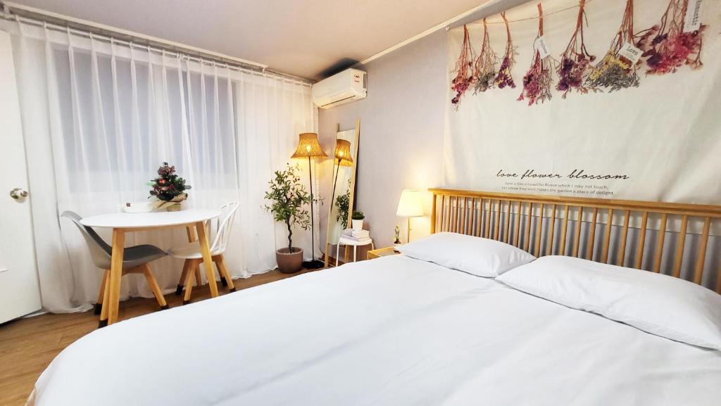 a bedroom with a white bed and a table at New Corestay # Edae Stn 2min 2R 2F # near Hongdae in Seoul