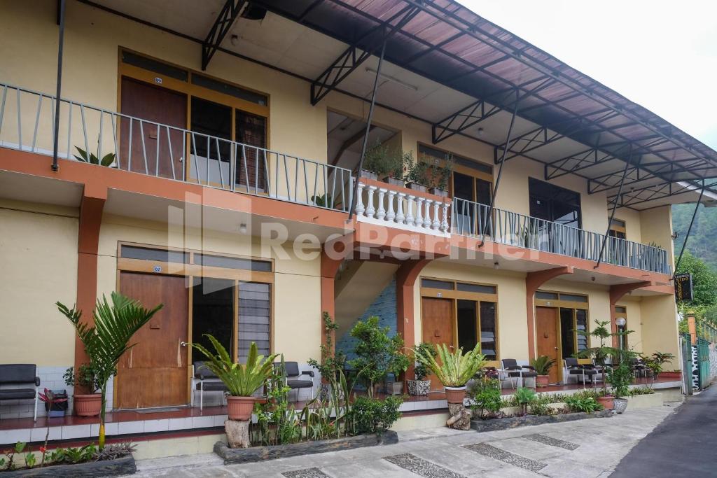 a building with balconies and potted plants on it at Hotel Sido Langgeng Tawangmangu Mitra RedDoorz in Karanganyar