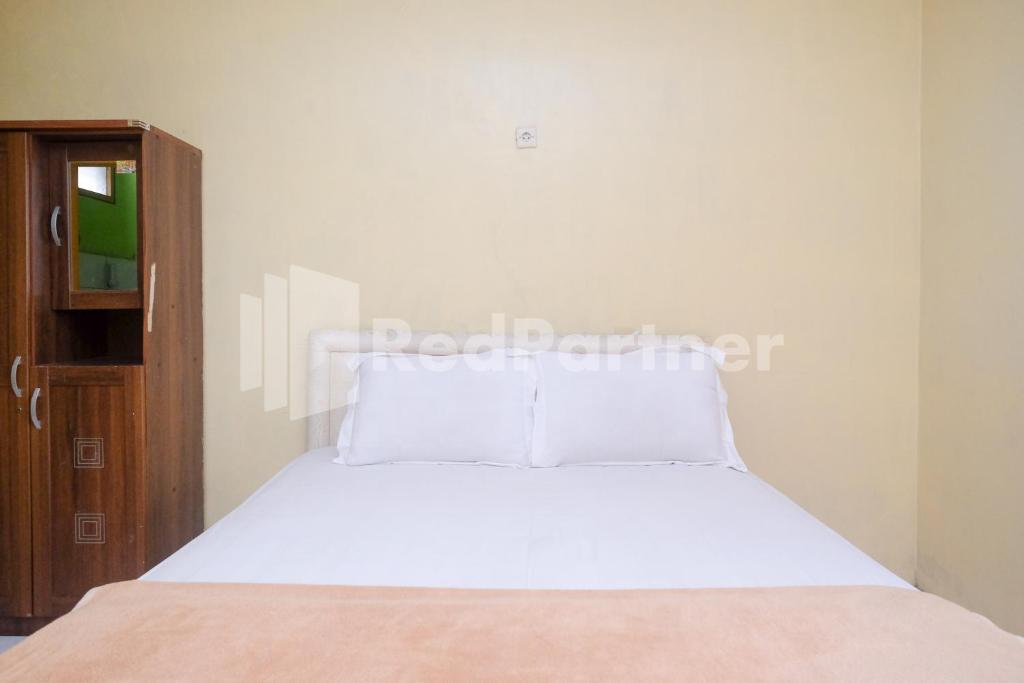 Rúm í herbergi á Hotel Sido Langgeng Tawangmangu Mitra RedDoorz