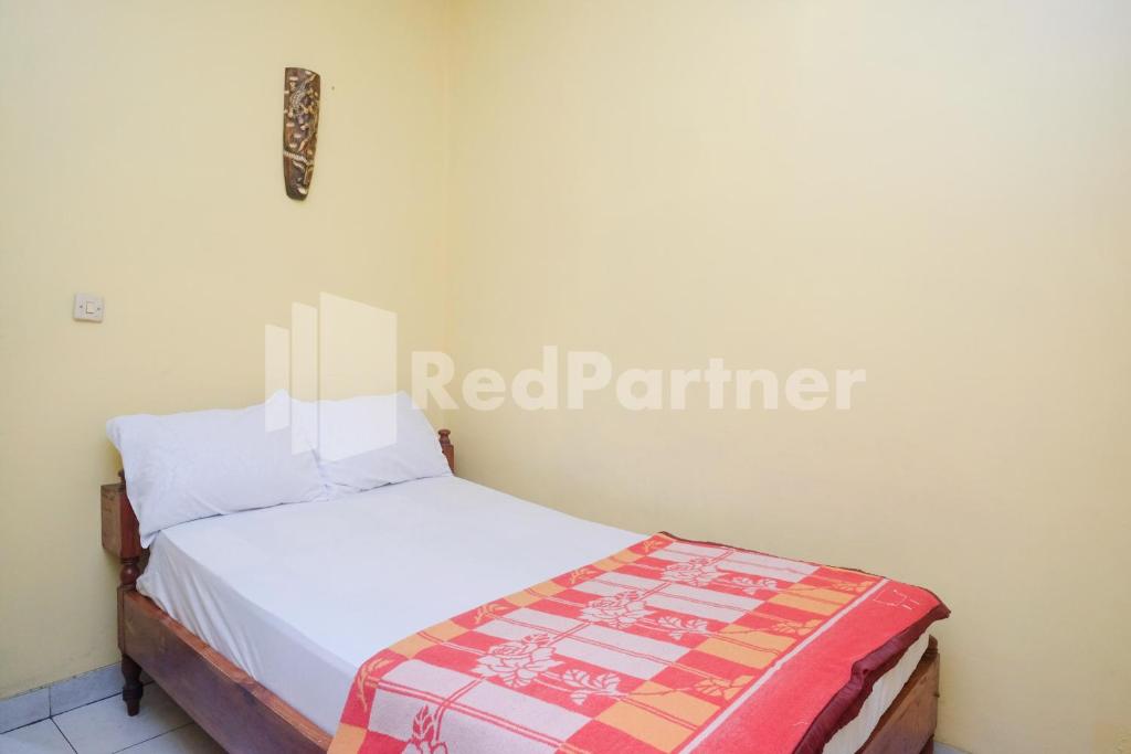 Rúm í herbergi á Hotel Sido Langgeng Tawangmangu Mitra RedDoorz