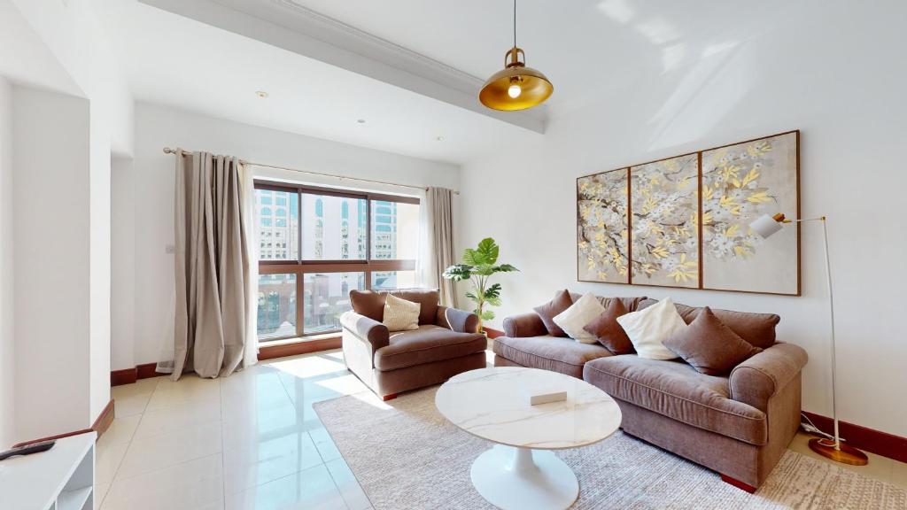 uma sala de estar com um sofá e uma mesa em Primestay - Golden Mile 2 1BR, Palm Jumeirah em Dubai