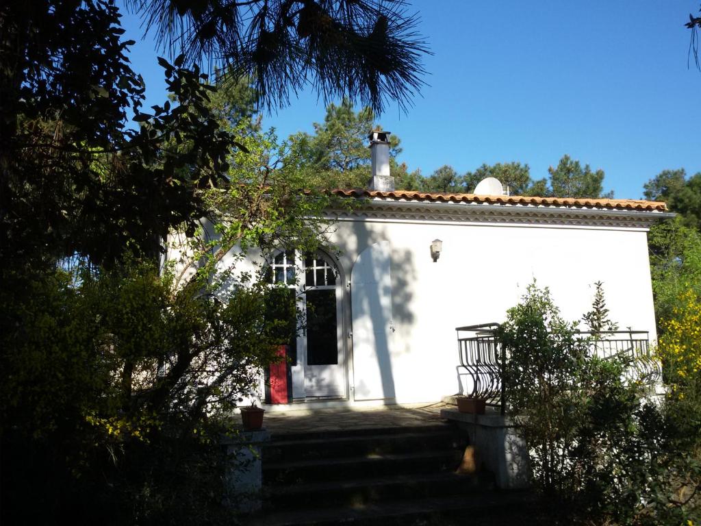 una pequeña casa blanca con escaleras delante en Large family house close to the beach en Les Mathes