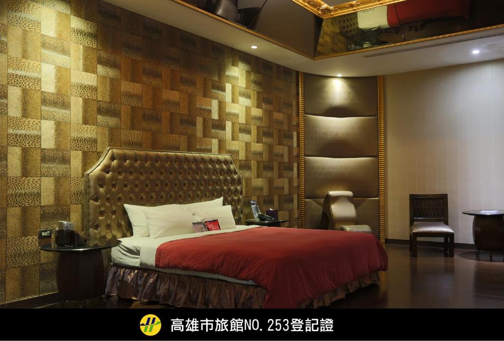 1 dormitorio con 1 cama con manta roja en Royal Group Motel Ming Chen Branch, en Kaohsiung