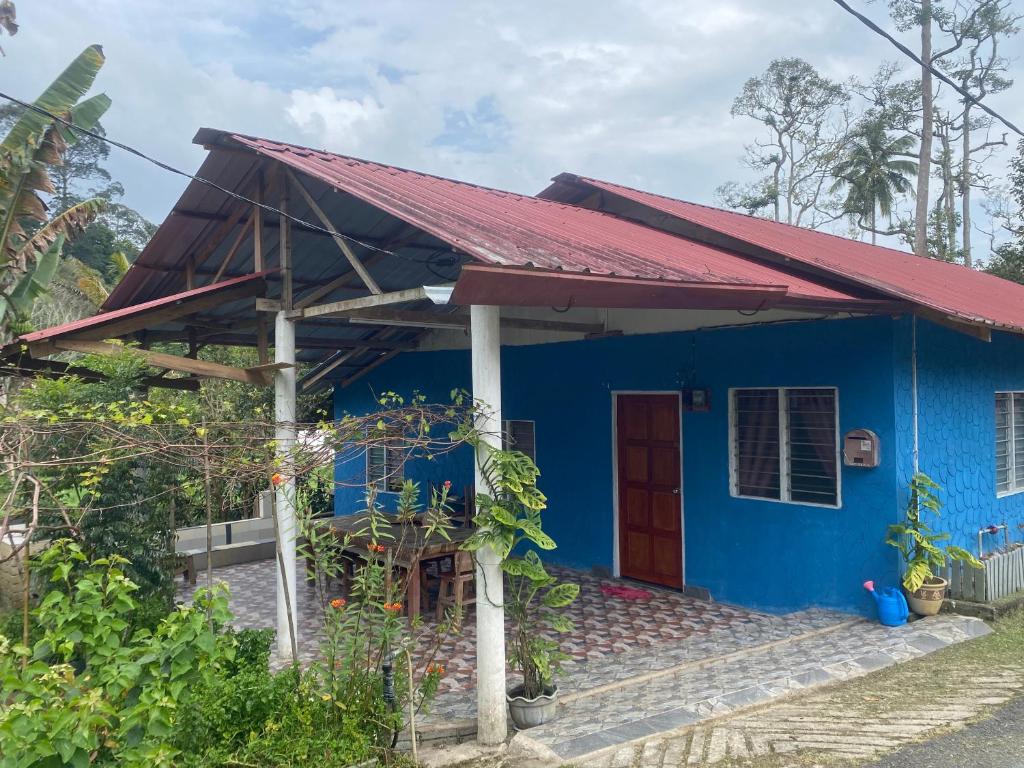 een blauw huis met een rood dak bij Chu Mon's Homestay Janda Baik (15 min from river) in Bentong